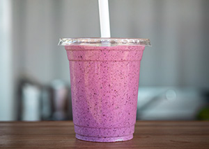 purple smoothie in a glass with straw